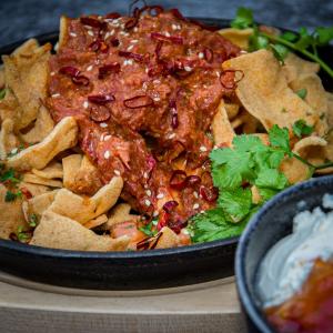 Cassave chips met rendang, pittige Cheddar en chilisaus